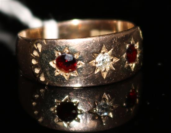 A late Victorian 9ct gold and gypsy set three stone garnet? and diamond ring, size O.